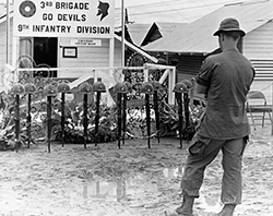 An unidentified soldier contemplates the memorial to Gary and his comrades.